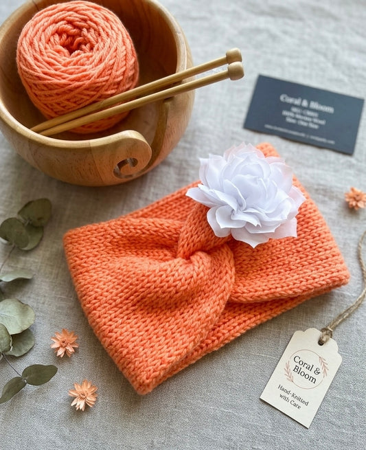 Hand-Knitted Coral Orange Twisted Headband with White Flower Detail – Soft Newborn & Baby Hair Accessory