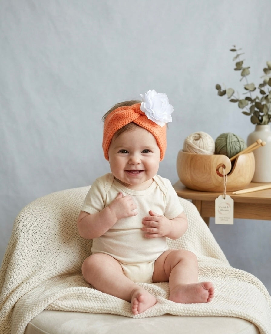 Hand-Knitted Coral Orange Twisted Headband with White Flower Detail – Soft Newborn & Baby Hair Accessory